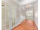 Foyer featuring warm wood floors, elegant wainscoting, and French doors at 8603 Robinson Meadow Ct, Charlotte, NC 28277