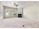 Spacious living room featuring a fireplace, large windows, and carpet flooring at 8603 Robinson Meadow Ct, Charlotte, NC 28277