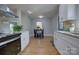 Bright dining area featuring light wood flooring, large windows and an adjoining modern kitchen at 8607 Larchmont Cir, Charlotte, NC 28214