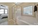Bathroom showcasing a soaking tub, glass shower, tile flooring, and natural light at 909 Autumn Glen Ct, Lake Wylie, SC 29710