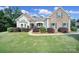 Charming single-Gathering home featuring a stone facade, manicured lawn, and beautiful landscaping at 909 Autumn Glen Ct, Lake Wylie, SC 29710