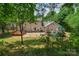 Large backyard featuring a deck, patio, playset, and lush greenery, perfect for outdoor activities and relaxation at 9423 Wood Ridge Dr, Charlotte, NC 28277
