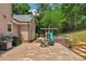 Backyard patio area with a grill, comfortable seating, and a play structure at 9423 Wood Ridge Dr, Charlotte, NC 28277
