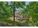 Scenic view of backyard featuring a deck, patio, playset, and lush greenery, offering privacy and tranquility at 9423 Wood Ridge Dr, Charlotte, NC 28277