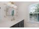 Bathroom with a modern vanity, stylish mirror, and a window providing natural light at 9423 Wood Ridge Dr, Charlotte, NC 28277