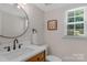 Modern bathroom with ship lap accent wall, updated fixtures, round mirror, and natural light at 9423 Wood Ridge Dr, Charlotte, NC 28277