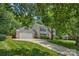 Suburban home on a large lot features an attached garage, long driveway, and lush landscaping at 9423 Wood Ridge Dr, Charlotte, NC 28277