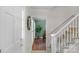 Entryway with hardwood floors and stairs, leading to a dining area with natural light at 9423 Wood Ridge Dr, Charlotte, NC 28277
