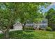 Traditional home with mature tree, attached garage, manicured lawn, and brick entryway at 9423 Wood Ridge Dr, Charlotte, NC 28277