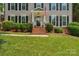 The front entrance features brick steps and classic shutters, showcasing curb appeal at 9423 Wood Ridge Dr, Charlotte, NC 28277