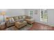 Comfortable living room with large sectional sofa, ottoman, and window with bright natural light at 9423 Wood Ridge Dr, Charlotte, NC 28277