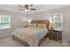 Cozy main bedroom features a large bed with floral bedding, bedside tables, and windows offering natural light at 9423 Wood Ridge Dr, Charlotte, NC 28277