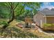 Backyard featuring a wooden playground set with a slide and swing, surrounded by lush landscaping at 9423 Wood Ridge Dr, Charlotte, NC 28277