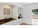 Wet bar with white cabinets, butcher block countertops, white shelving, and black fixture at 9423 Wood Ridge Dr, Charlotte, NC 28277