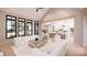 Open-concept living room with large windows, contemporary furnishings, and a view of the modern kitchen at 0000 Woodhill Cove Ln # 5, Denver, NC 28037