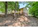 Backyard view of a yellow siding house with chainlink fence and wooded area surrounding the property at 103 Sycamore Rd, Salisbury, NC 28147
