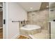 Bright bathroom featuring a soaking tub with tile surround and a separate glass-enclosed shower at 103 Sycamore Rd, Salisbury, NC 28147