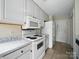 Kitchen with white cabinets, white appliances, and grey countertops at 1148 Stallings Rd, Matthews, NC 28104