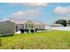 Large backyard featuring a well maintained lawn, shed, patio and sunroom on a sunny day at 129 Sara Ln, Statesville, NC 28625