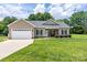 Charming single-story home with a two-car garage, manicured lawn, and attractive landscaping at 129 Sara Ln, Statesville, NC 28625