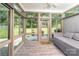 Bright sunroom featuring many windows, a ceiling fan and a lounge space overlooking a beautiful yard at 129 Sara Ln, Statesville, NC 28625