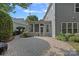 A cozy backyard featuring brick patio, well-manicured greenery, and access to an enclosed porch at 16909 Red Cow Rd, Charlotte, NC 28277