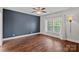 Bedroom featuring hardwood floors, a ceiling fan, modern lighting, and an accent wall at 16909 Red Cow Rd, Charlotte, NC 28277