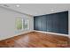 Spacious bedroom with hardwood floors, wainscoting, a navy accent wall and natural light at 16909 Red Cow Rd, Charlotte, NC 28277