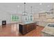 Spacious kitchen features a large island with seating and pendant lighting, with a seamless flow to the living area at 16909 Red Cow Rd, Charlotte, NC 28277