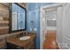 Rustic powder room with granite countertop, wood accent wall, and view to a chandelier-lit room at 16909 Red Cow Rd, Charlotte, NC 28277