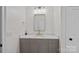 Well-lit powder room featuring a modern vanity with stone countertop and a decorative mirror at 16909 Red Cow Rd, Charlotte, NC 28277