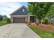 Charming home features a blue facade, stone accents, a brown garage door, and a well-maintained front yard at 1712 Askern Ct, Waxhaw, NC 28173