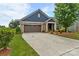 Charming home featuring a blue facade, stone accents, a brown garage door, and lush landscaping at 1712 Askern Ct, Waxhaw, NC 28173