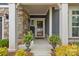 Welcoming front porch with stone pillars, comfortable seating, and decorative plants, inviting relaxation at 1712 Askern Ct, Waxhaw, NC 28173