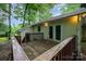 Exterior view from weathered deck towards siding and heavily treed lot at 1802 Deer St, Charlotte, NC 28214