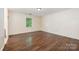 Bedroom with dark hardwood floors, white walls, and a window at 1802 Deer St, Charlotte, NC 28214