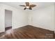 Bedroom with hardwood floors, white walls, a ceiling fan, and two doors at 1802 Deer St, Charlotte, NC 28214