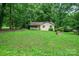 Charming single-story home with a brick exterior and a cozy front porch surrounded by lush trees and greenery at 1802 Deer St, Charlotte, NC 28214