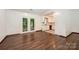 Open-concept living area with hardwood floors, kitchen access, and doors to the outdoors at 1802 Deer St, Charlotte, NC 28214