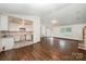 Open layout featuring hardwood floors, a glimpse into the kitchen, and a bright window at 1802 Deer St, Charlotte, NC 28214