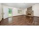 Open living space with a brick fireplace, hardwood flooring, and neutral walls at 1802 Deer St, Charlotte, NC 28214