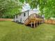 Spacious backyard with lush green lawn, wooden deck, and white painted brick exterior at 2114 Thurmond Pl, Charlotte, NC 28205
