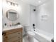 A bathroom with white tiled walls and a modern vanity, bath and shower combination at 2114 Thurmond Pl, Charlotte, NC 28205