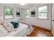 Bright bedroom with hardwood floors, a light-colored bed, and three windows at 2114 Thurmond Pl, Charlotte, NC 28205