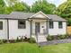 Quaint home featuring updated landscaping, a gray door, and black framed windows at 2114 Thurmond Pl, Charlotte, NC 28205