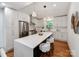 Stylish kitchen featuring white cabinets, stainless steel appliances, and a large island with seating at 2114 Thurmond Pl, Charlotte, NC 28205