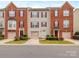 Charming townhome with brick and siding exterior, red shutters, well-kept lawn, and driveway with attached garage at 2169 Belle Vernon Ave, Charlotte, NC 28210
