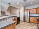 Kitchen featuring wood cabinets, stainless steel appliances, grey countertops, and wood-look flooring at 2169 Belle Vernon Ave, Charlotte, NC 28210