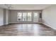 Spacious living room with wood-look floors, neutral paint, ample natural light from multiple windows, and a door to the outside at 2169 Belle Vernon Ave, Charlotte, NC 28210