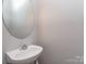 Powder room featuring a modern sink, faucet, and an oval mirror at 2169 Belle Vernon Ave, Charlotte, NC 28210